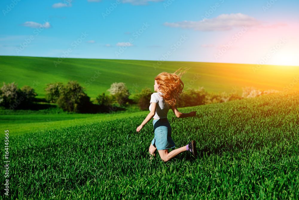 Young beautiful woman running on a green field Young beautiful woman running on a green field