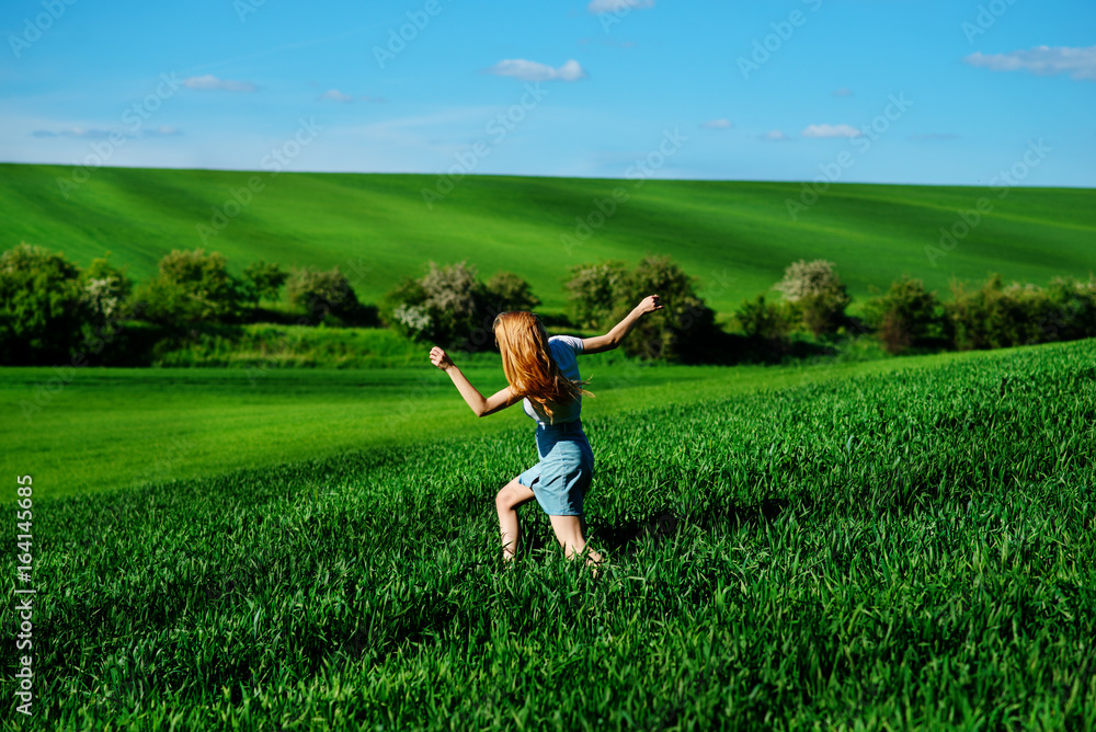 Young beautiful woman running on a green field Young beautiful woman running on a green field