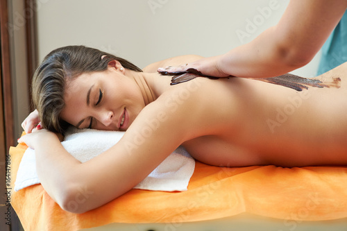 Young woman take a chocolate massage in a spa