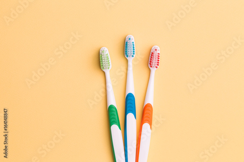 Toothbrushes on empty orange background