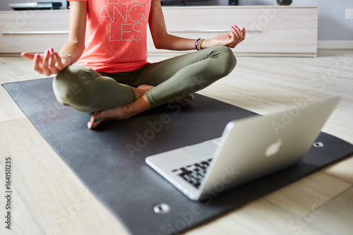 Ragazza fa yoga a casa con pc photo