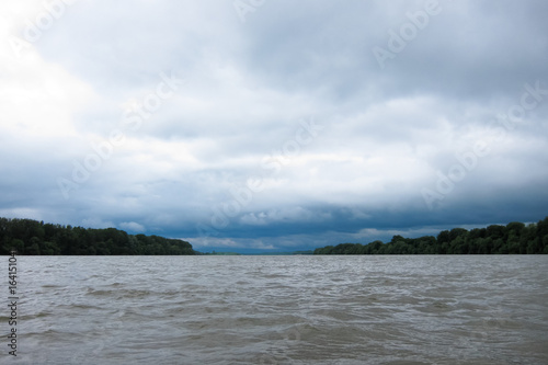 Storm sky with heavy gray clouds over the Danube River