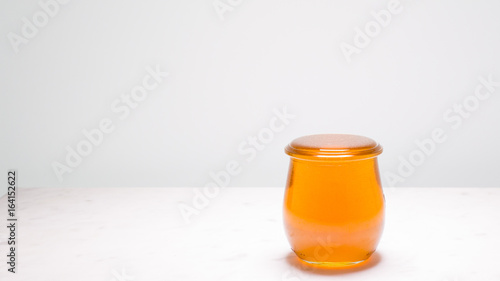 Perfectly full jar of honey with copy space to the left.  Life is full and sweet!