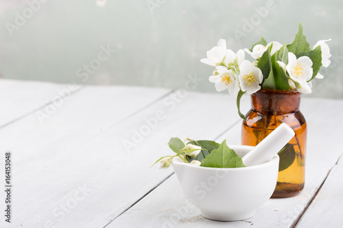 Spa concept - making essential oil with jasmine flowers photo