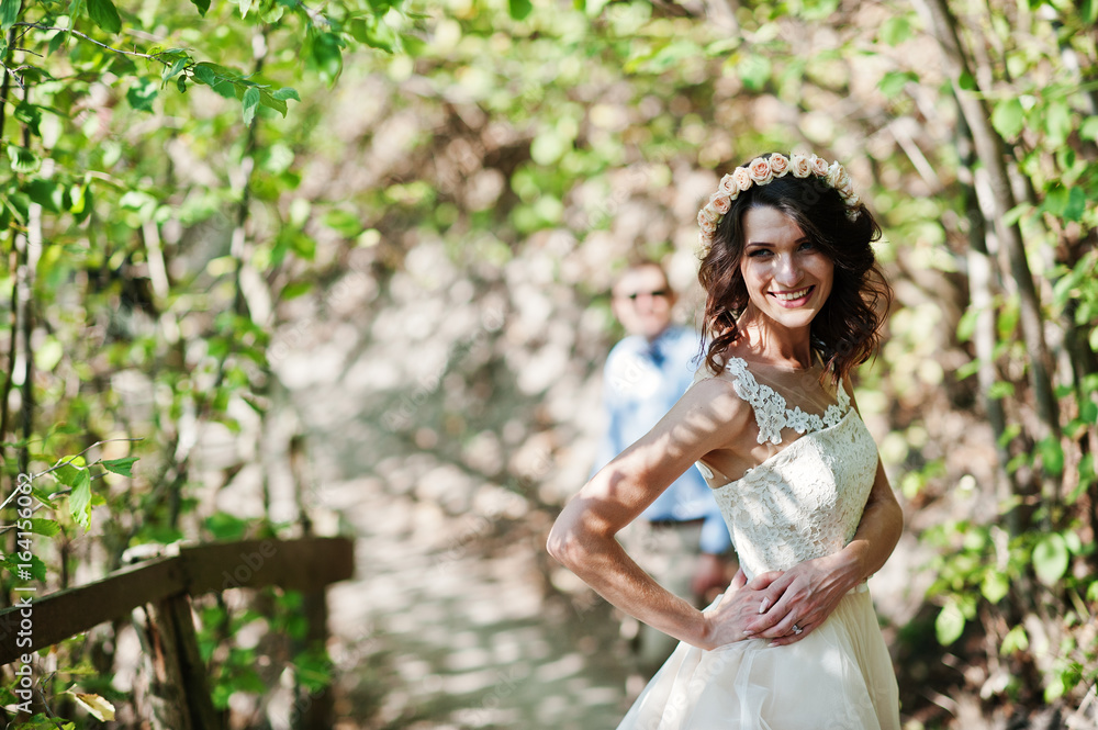 Fantastically-looking couple strolling in the forest on their wedding day. Fantastically-looking couple strolling in the forest on their wedding day.