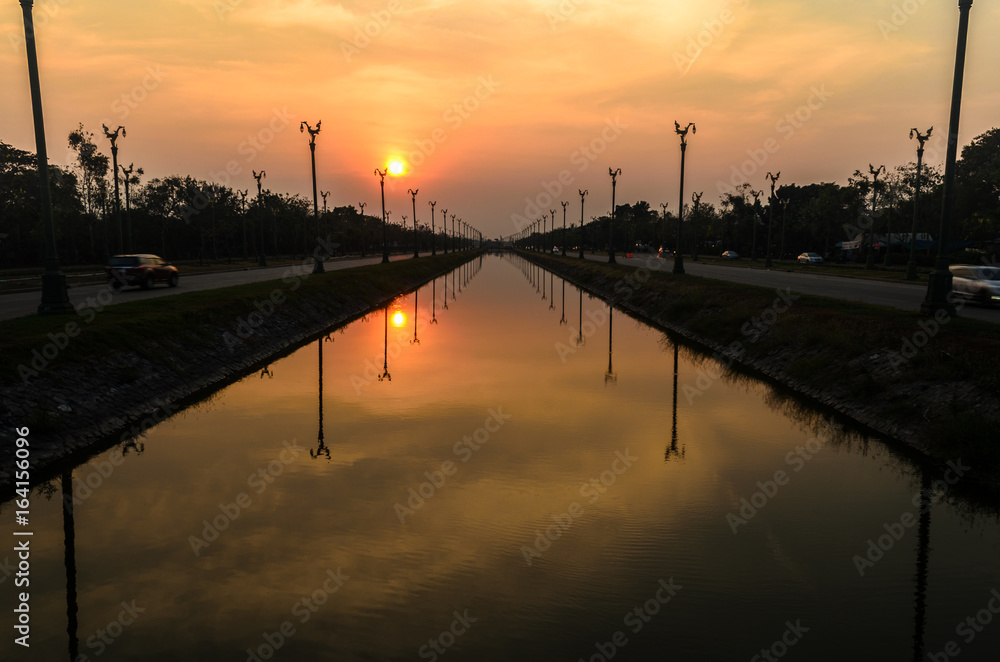 Sunset over a highway Utthayan Road and reflection on the river.