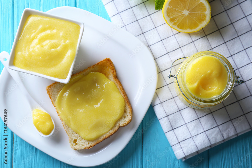 Composition with fresh toast and delicious lemon curd on wooden table Composition with fresh toast and delicious lemon curd on wooden table