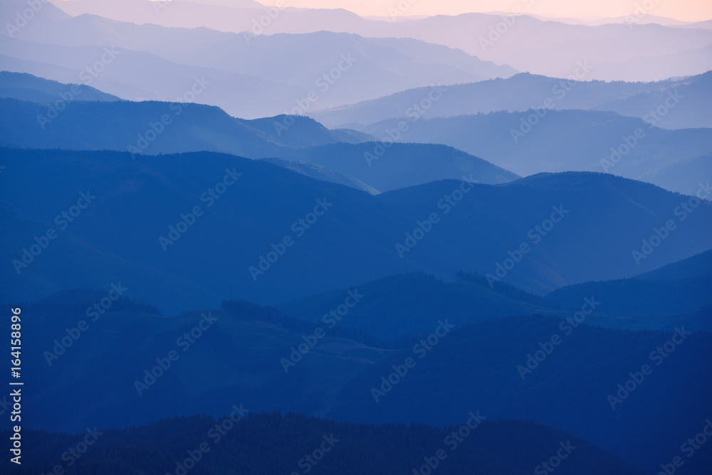 Carpathian mountains summer sunset landscape with abstract gradient of mountain peaks in blue colors, natural travel outdoor background