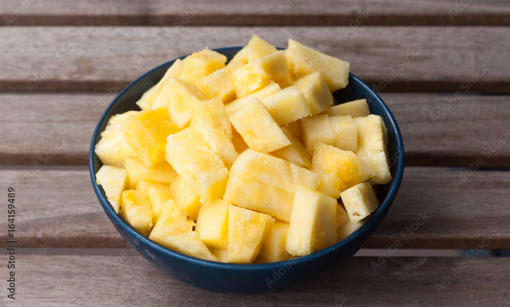 Pineapple slices in a blue ball on a wooden background Pineapple slices in a blue ball on a wooden background