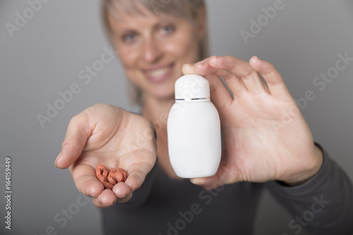 Beautiful lady holding a medicine pill in her hand