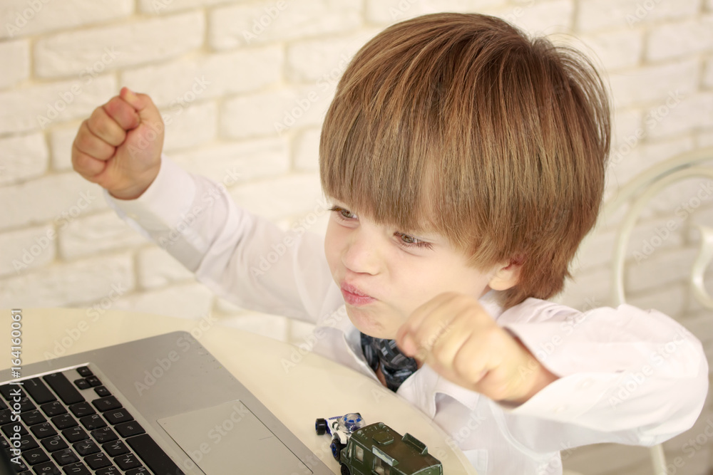 Emotional little boy using laptop Emotional little boy using laptop