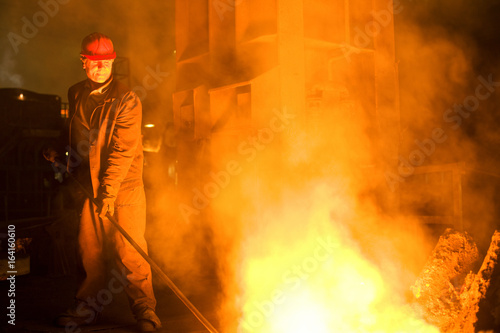 Worker working with a molten metal in the foundry