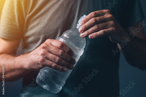 Man with bottle of fresh drinking water photo