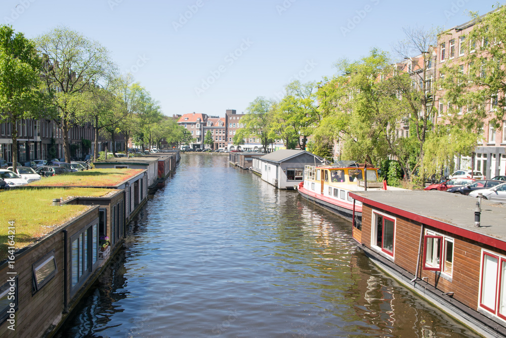Colorful traditional living houses and houseboats along the canal in Amsterdam, Netherlands