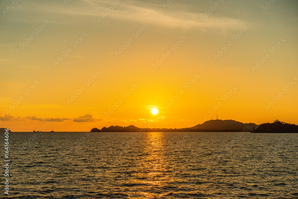 Beautiful seascape sunset view from sea with island on horizon