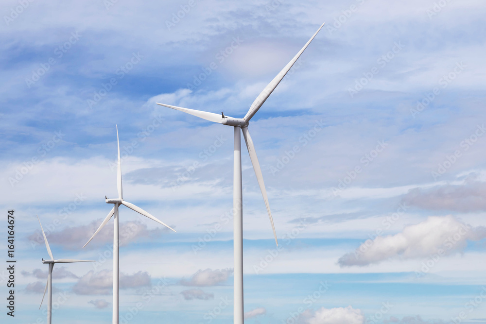 white wind turbines generating electricity in wind power station under blue sky background white wind turbines generating electricity in wind power station under blue sky background