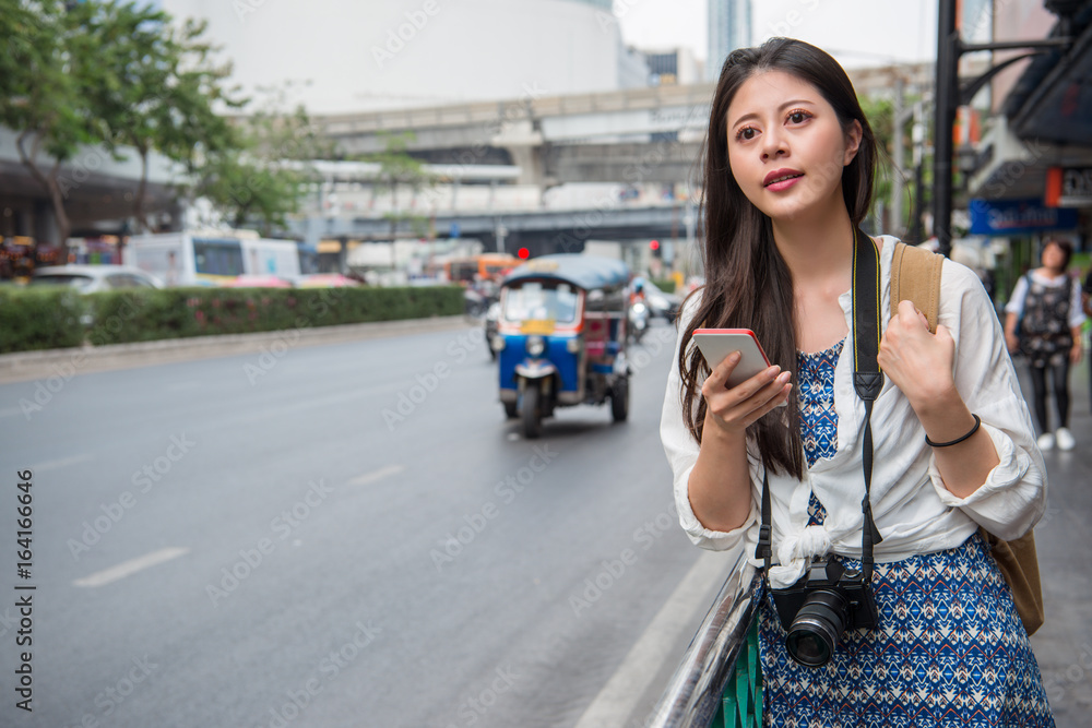 Fototapeta premium Woman walking in bangkok city using phone