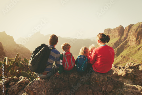 family with three kids hiking in mountains