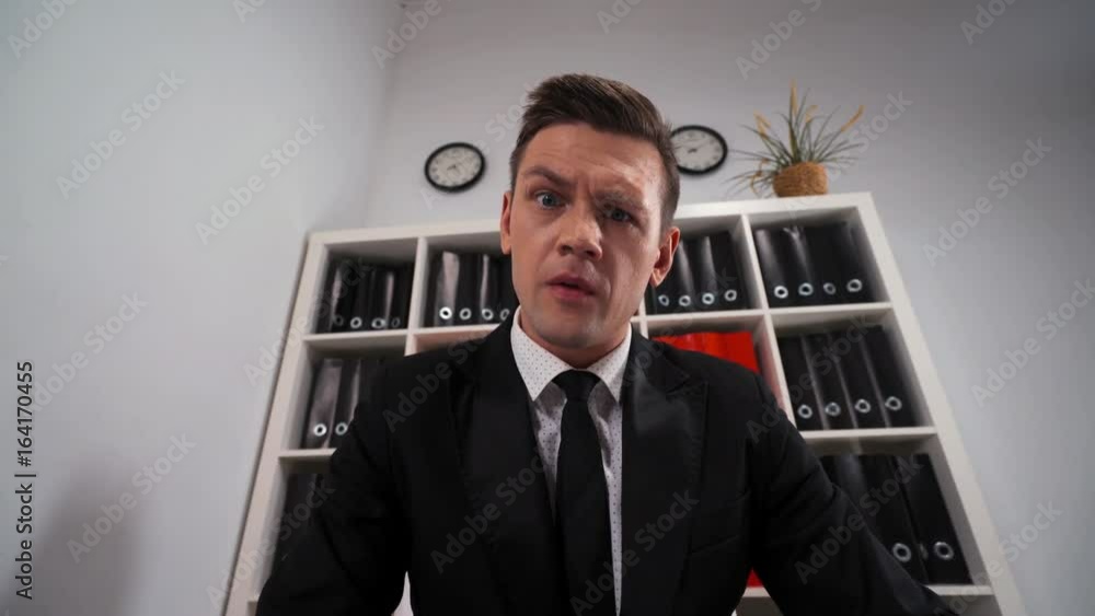 Young handsome businessman looks thru a magnifying lens and find some interesting in You. POV wide shot. He move spectacle directly on camera and become bigger. Big eye. Young handsome businessman looks thru a magnifying lens and find some interesting in You. POV wide shot. He move spectacle directly on camera and become bigger. Big eye.