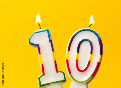Photography Number 10 birthday celebration candle against a bright yellow background