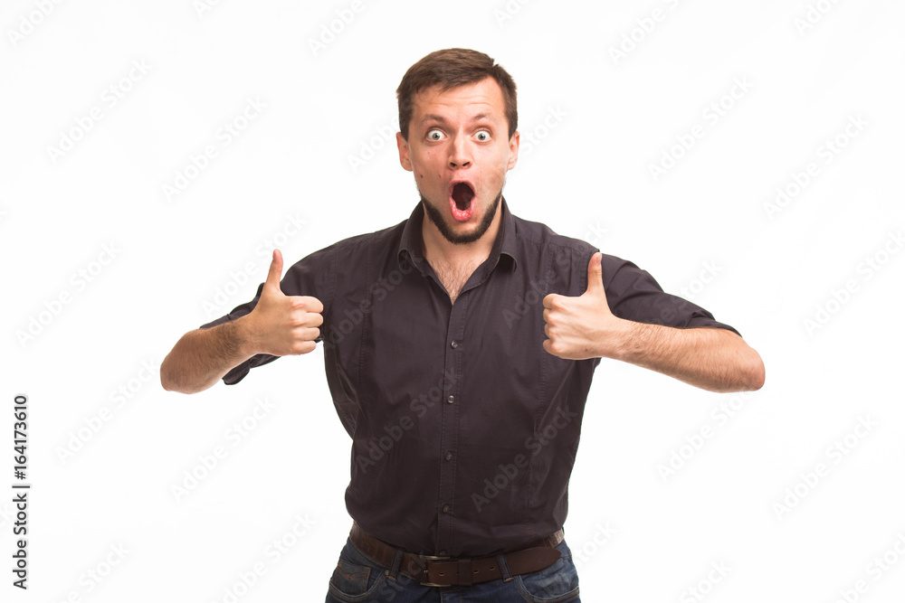 Young surprised man portrait of a confident businessman showing presentation, pointing paper placard gray background. Ideal for banners, registration forms, presentation, landings, presenting concept. Young surprised man portrait of a confident businessman showing presentation, pointing paper placard gray background. Ideal for banners, registration forms, presentation, landings, presenting concept.