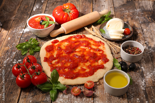 cooking pizza with tomato sauce,mozzarella and basil