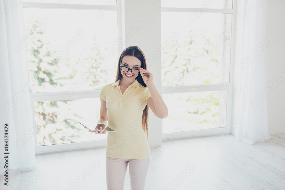 Brunette woman realtor with beaming smile is welcoming you in new apartment, show you around, long brown hair, glasses, casual smart, light white room Brunette woman realtor with beaming smile is welcoming you in new apartment, show you around, long brown hair, glasses, casual smart, light white room