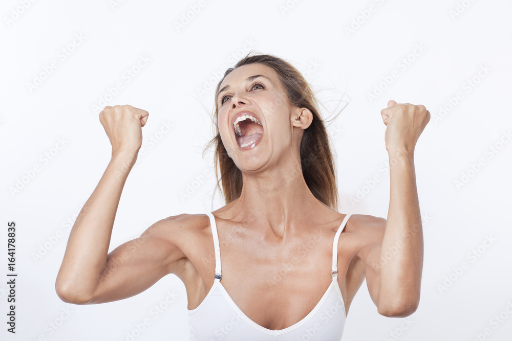 portrait d'une femme riant et criant les bras en l'air Stock Photo