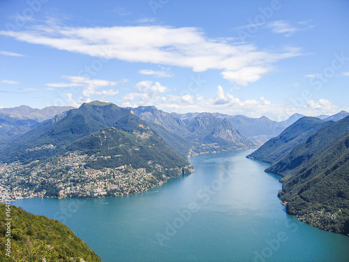 Aerial view of Lugano city with houses, lake and cityscape, and alpine Swiss mountains