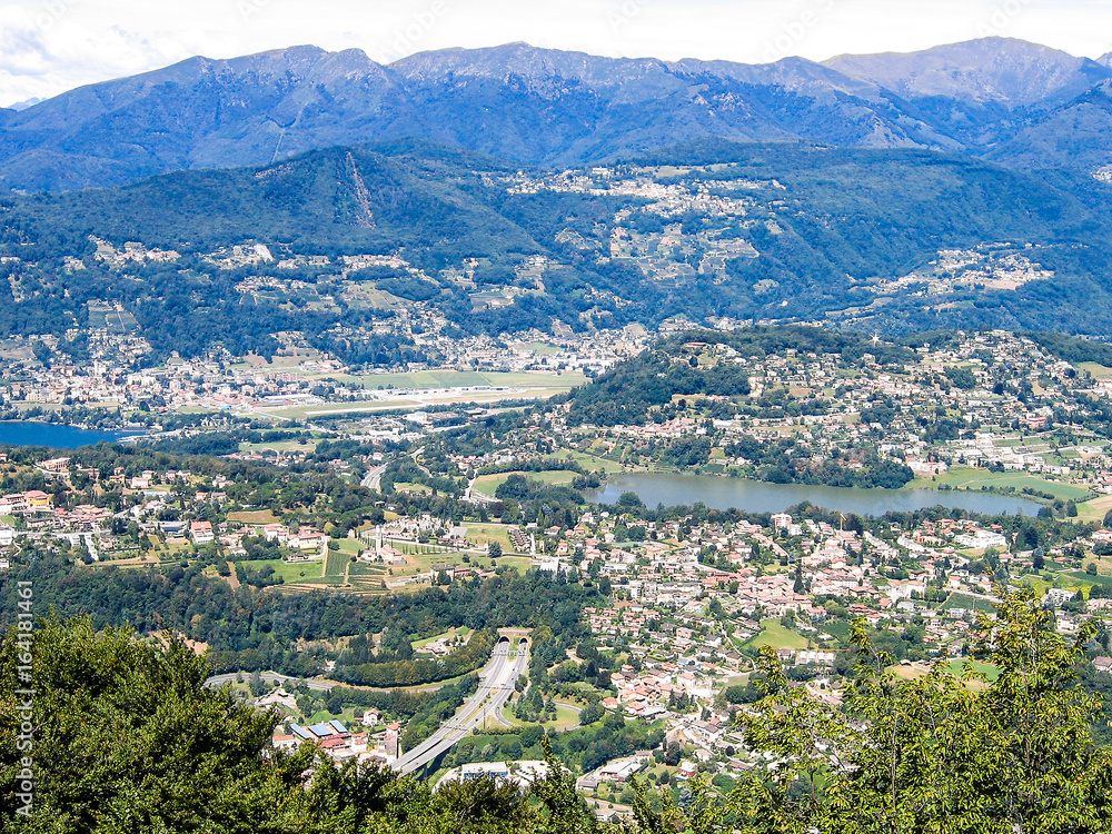 Aerial view of Lugano city with houses, lake and cityscape, and alpine Swiss mountains in Switzerland