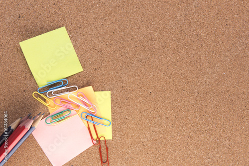 Post it notes, pencils and paper clips on a wooden background with copy space 