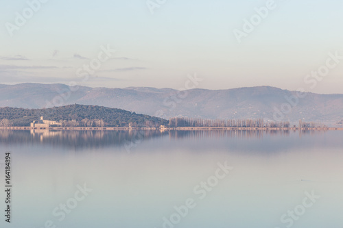 Isola Polvese (Trasimeno Lake, Umbria) perfectly reflecting on water, with warm sunset colors