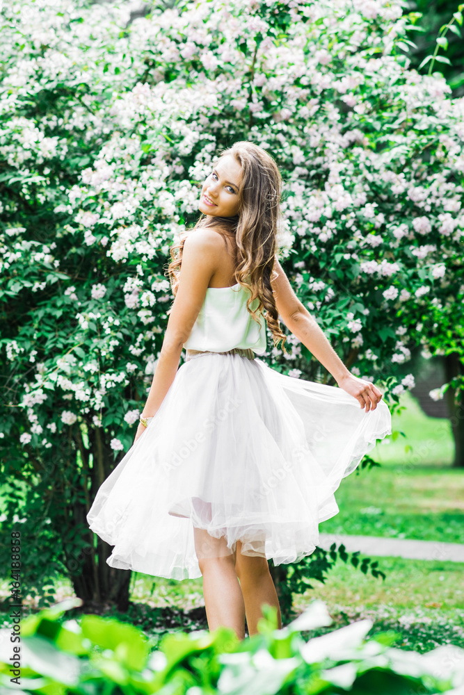 Portrait of beautiful girl near flowering branches in spring garden Portrait of beautiful girl near flowering branches in spring garden