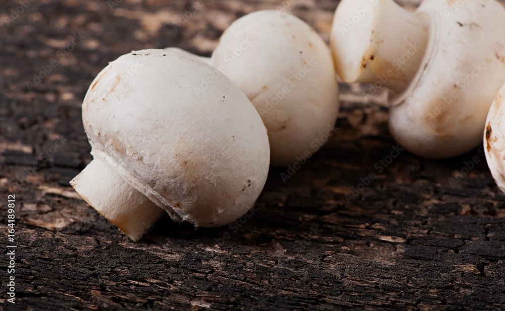 Mushrooms champignons on an old wooden background. Mushrooms champignons on an old wooden background.