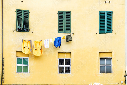 Clothes hanged to dry on the facade of a house in Lucca, Italy.
