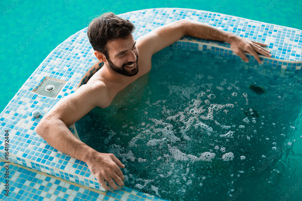 Attractive man enjoying spending time in jacuzzi