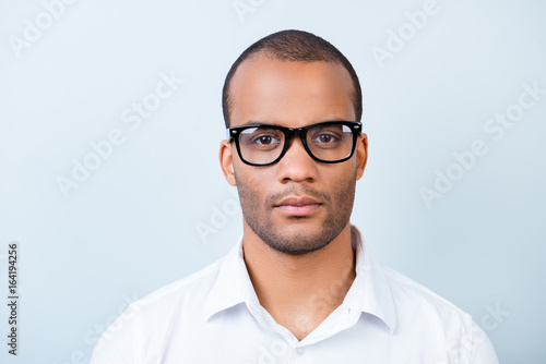 Fototapeta Naklejka Na Ścianę i Meble -  Successful young handsome american guy banker in formal outfit on pure background in glasses. Severe and harsh, rich and confident