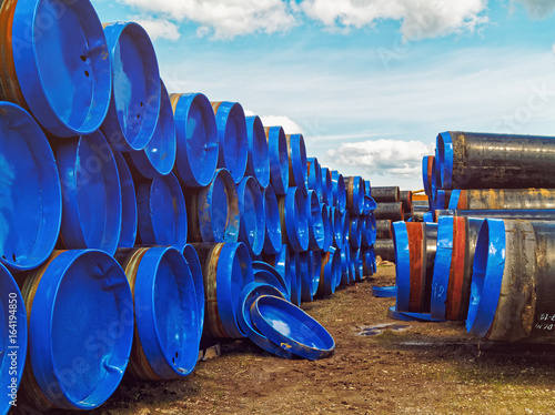 Metal pipes of large diameter with an outer covering and end caps are located on the industrial site