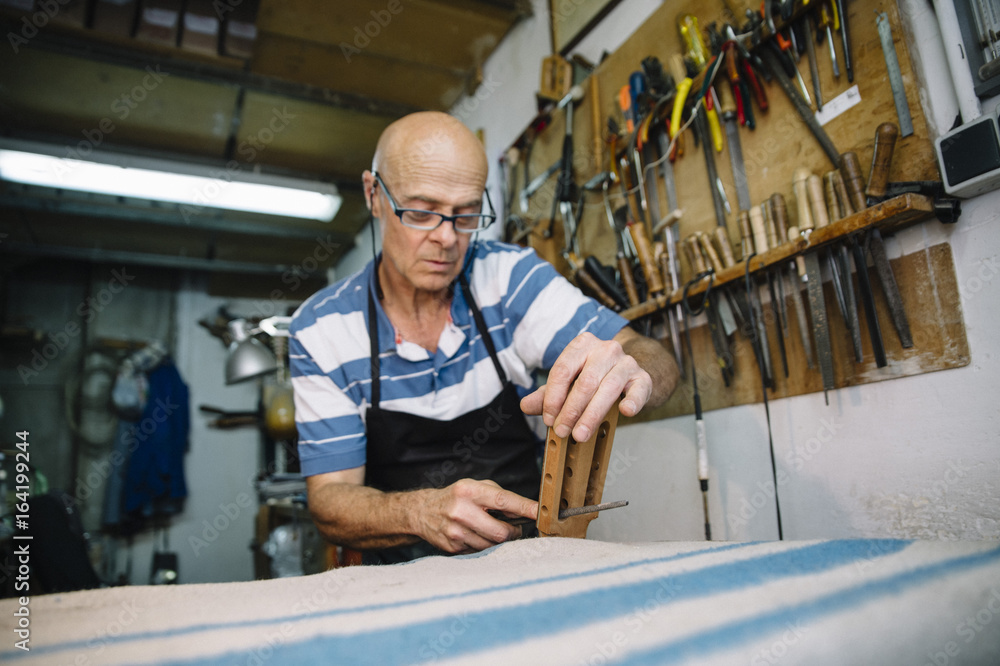 Man working at a Workshop with Musical instruments Man working at a Workshop with Musical instruments