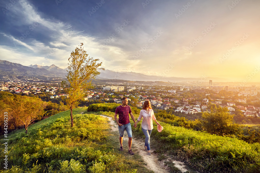 Couple in the park at sunset city view