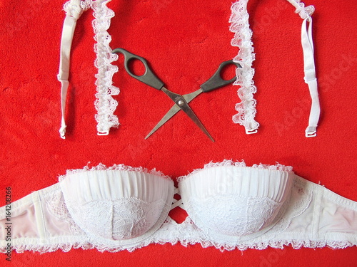 White lace strapless bra with scissors cutting the straps