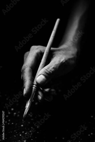 The artist's hands hold a brush
