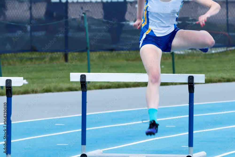 Obraz premium High school female running the long hurdles