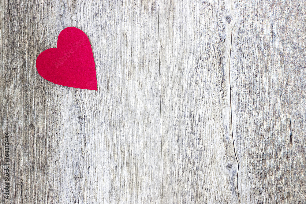 A red heart on a gray wooden background. Copy space. A red heart on a gray wooden background. Copy space.