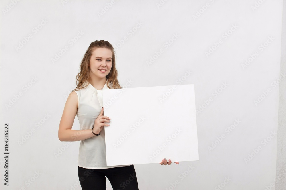 Young woman holding blank poster.Smiling woman sign board holding. Girl showing banner with copy space. Young woman holding blank poster.Smiling woman sign board holding. Girl showing banner with copy space.