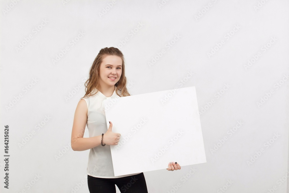 Young woman holding blank poster.Smiling woman sign board holding. Girl showing banner with copy space. Young woman holding blank poster.Smiling woman sign board holding. Girl showing banner with copy space.