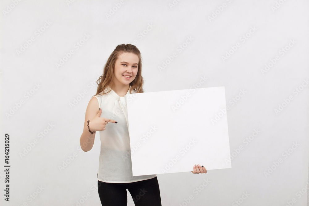 Young woman holding blank poster.Smiling woman sign board holding. Girl showing banner with copy space. Young woman holding blank poster.Smiling woman sign board holding. Girl showing banner with copy space.