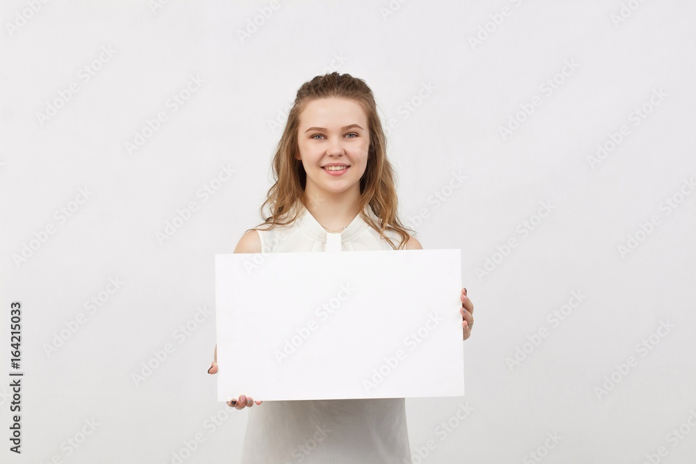 Young woman holding blank poster.Smiling woman sign board holding. Girl showing banner with copy space. Young woman holding blank poster.Smiling woman sign board holding. Girl showing banner with copy space.