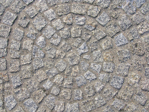 Cobble stone brick road abstract background. Cobblestone pavement with circular pattern