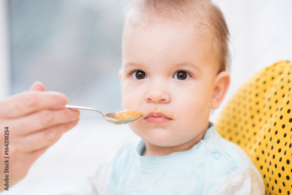 grandmother gives baby food from a spoon grandmother gives baby food from a spoon